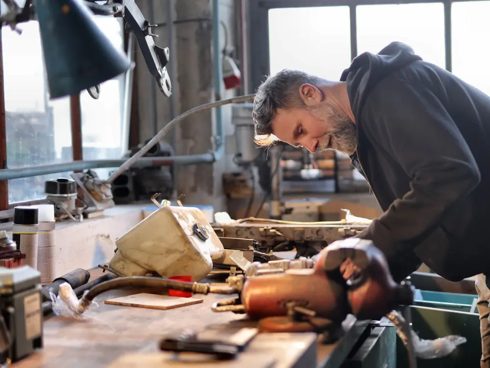 A tradesperson at a workbench in a small manufacturing shop